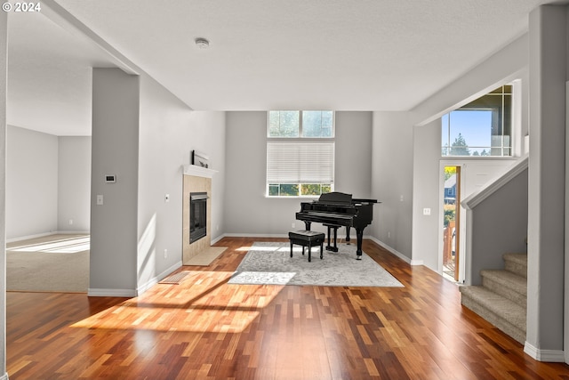 sitting room featuring a tile fireplace and hardwood / wood-style floors