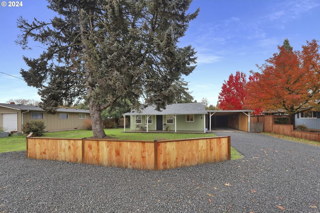 ranch-style house featuring a front yard and a carport