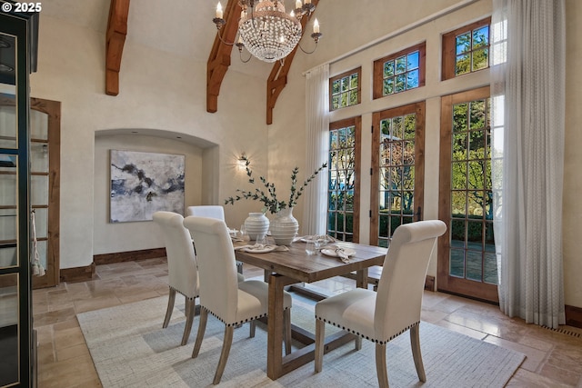 dining space with beam ceiling, a chandelier, and high vaulted ceiling