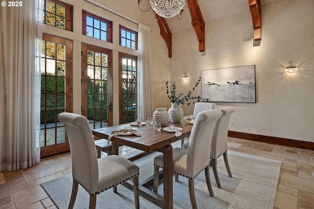 dining space with a towering ceiling, beam ceiling, and a notable chandelier