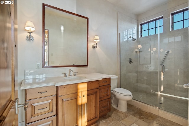 bathroom with vanity, toilet, and a shower with door