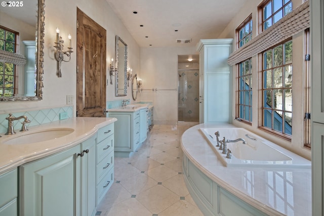 bathroom with independent shower and bath and vanity