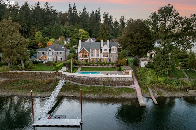 back house at dusk featuring a water view