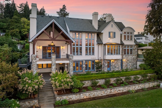 back house at dusk with a balcony