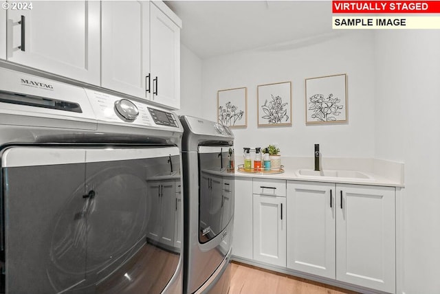 washroom featuring cabinets, light hardwood / wood-style floors, washer and clothes dryer, and sink