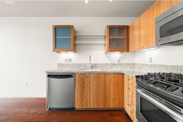 kitchen featuring sink, stainless steel appliances, dark hardwood / wood-style flooring, and light stone countertops