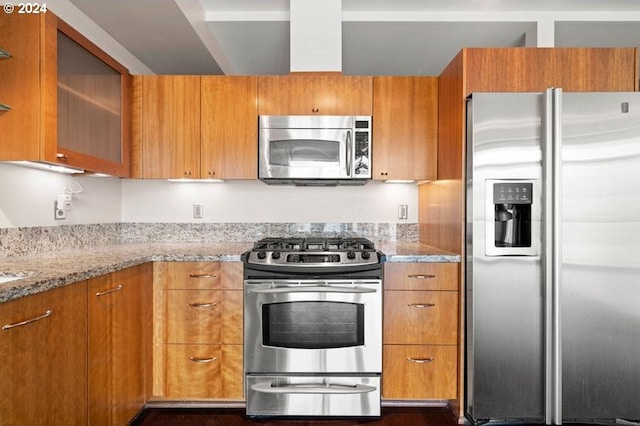 kitchen featuring stainless steel appliances, dark wood-type flooring, and light stone countertops