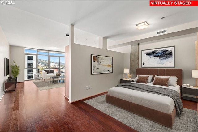 bedroom featuring expansive windows and hardwood / wood-style floors