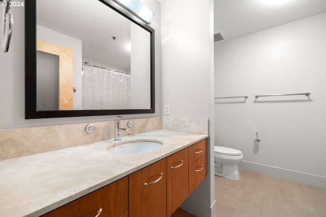 bathroom featuring toilet, vanity, and tile patterned floors