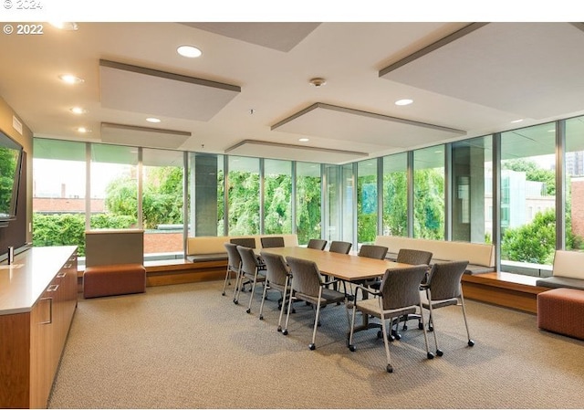 dining space featuring a wall of windows and light carpet