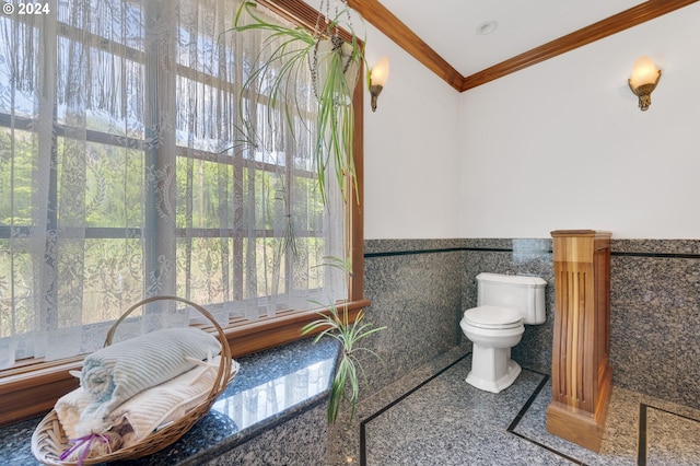 bathroom with toilet, tile walls, and crown molding