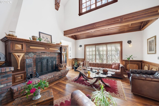 living room featuring a fireplace, beam ceiling, and hardwood / wood-style flooring