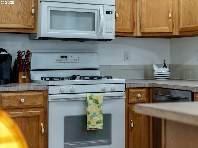 kitchen with brown cabinetry, white appliances, and light countertops