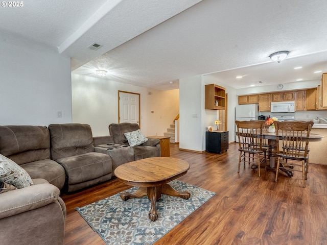 living area featuring visible vents, dark wood finished floors, recessed lighting, stairs, and a textured ceiling