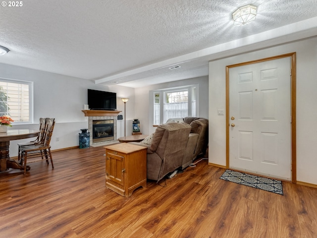4196 SE Pinehurst Ave, Milwaukie, OR 97267 - living room featuring a textured ceiling, wood finished floors, a tiled fireplace, and baseboards
