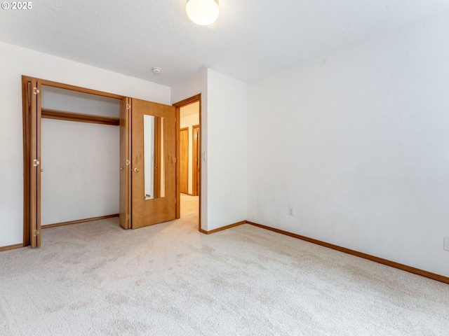 unfurnished bedroom with baseboards, carpet floors, and a closet