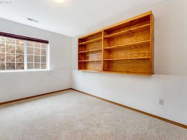 empty room with visible vents, carpet floors, and baseboards