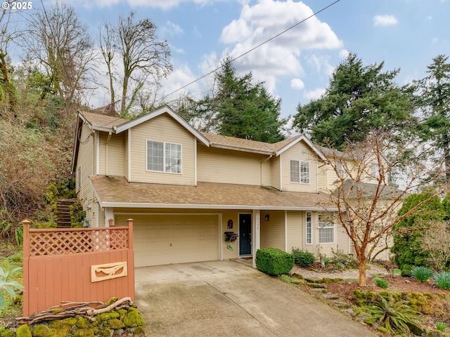 traditional-style house with concrete driveway, an attached garage, and a shingled roof