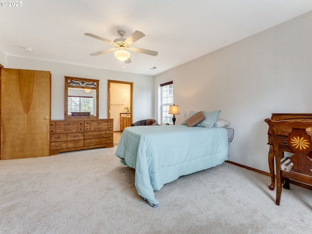 carpeted bedroom with baseboards, multiple windows, connected bathroom, and a ceiling fan