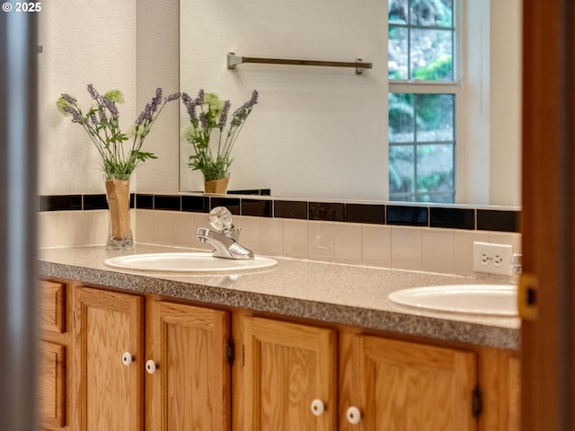 bathroom featuring double vanity, decorative backsplash, and a sink