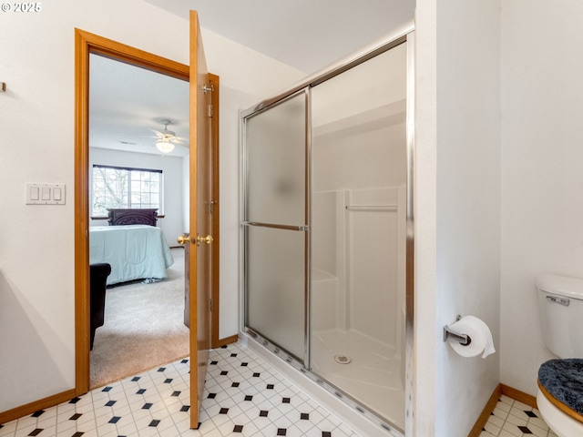 ensuite bathroom with baseboards, ceiling fan, a shower stall, toilet, and connected bathroom