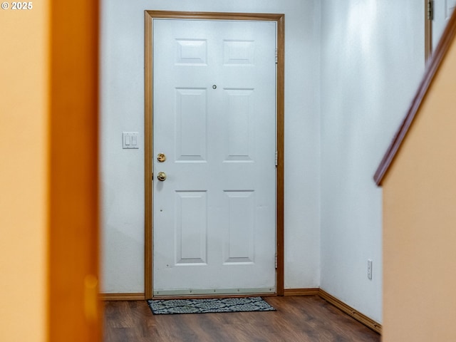 foyer entrance with dark wood-style floors and baseboards