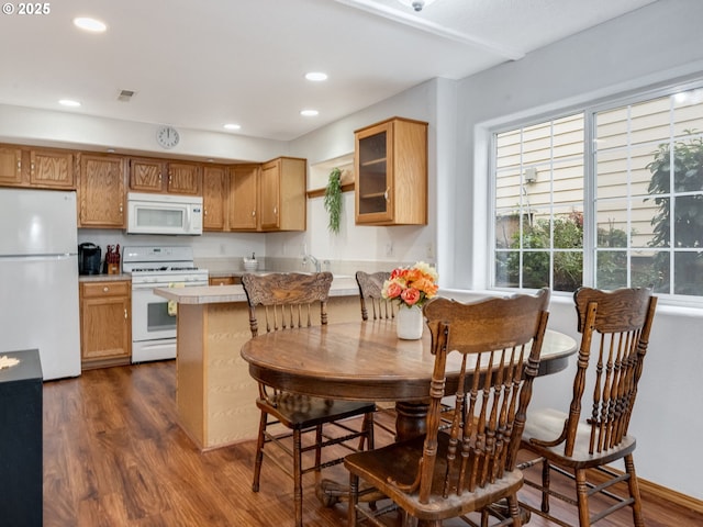 kitchen with dark wood finished floors, recessed lighting, white appliances, and glass insert cabinets