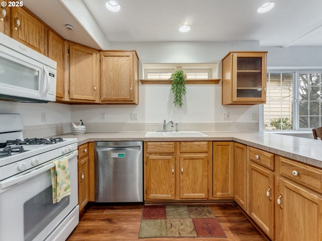 kitchen featuring dark wood finished floors, light countertops, recessed lighting, white appliances, and a sink