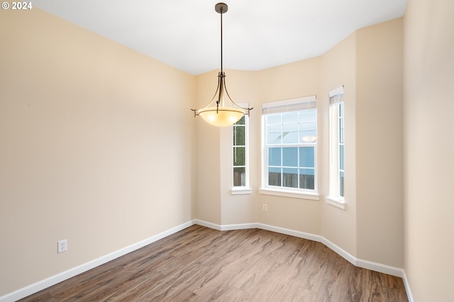 unfurnished room featuring baseboards and wood finished floors