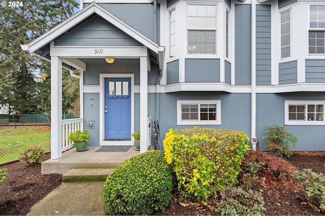doorway to property with fence and stucco siding