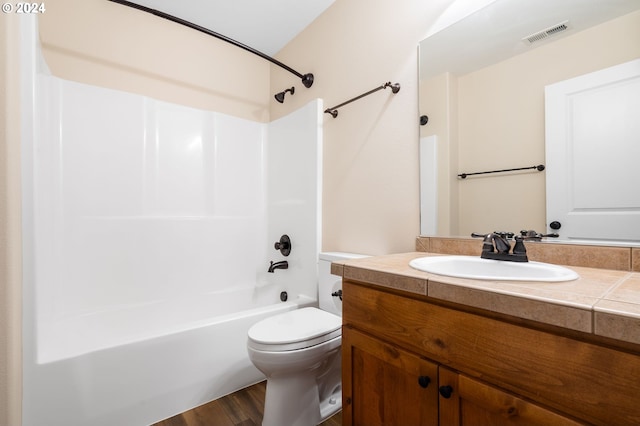 bathroom with bathtub / shower combination, visible vents, toilet, vanity, and wood finished floors