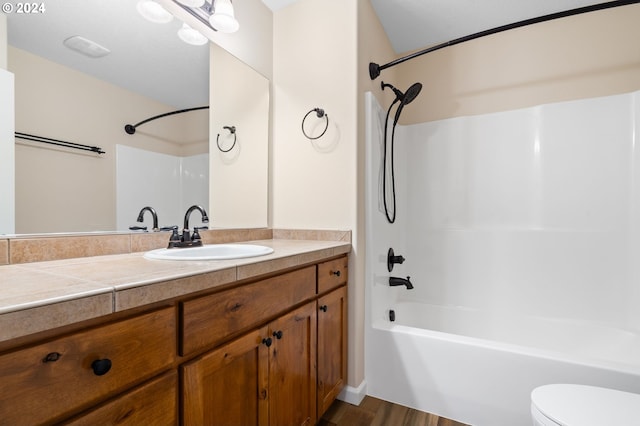 full bathroom featuring washtub / shower combination, vanity, toilet, and wood finished floors