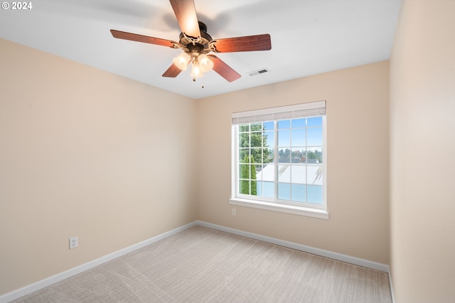 empty room featuring visible vents, baseboards, ceiling fan, and light carpet