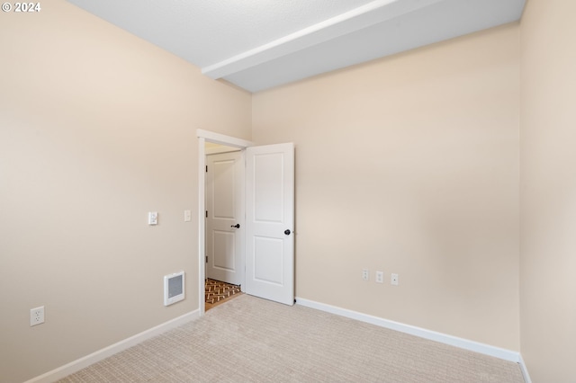 spare room featuring carpet flooring, visible vents, and baseboards