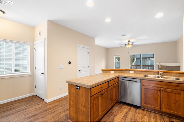 kitchen featuring stainless steel dishwasher, ceiling fan, sink, light hardwood / wood-style floors, and plenty of natural light