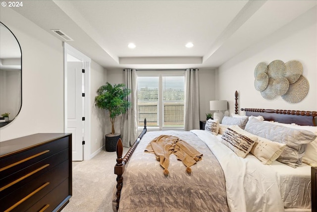 carpeted bedroom with a raised ceiling