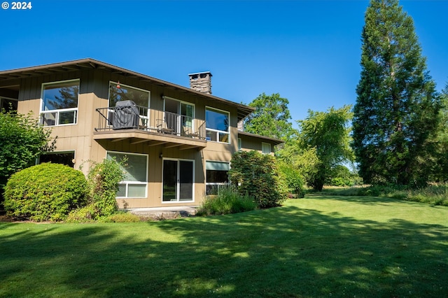 rear view of house featuring a yard