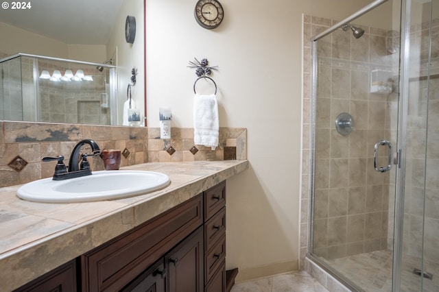 bathroom featuring vanity, walk in shower, tile patterned floors, and backsplash