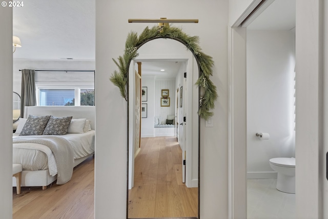 bedroom with light hardwood / wood-style floors and connected bathroom