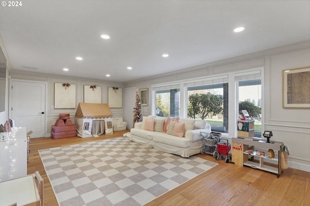 living room featuring crown molding and light hardwood / wood-style flooring