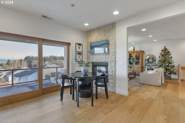 dining area featuring a fireplace and light wood-type flooring