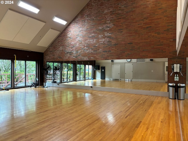 interior space featuring light wood-type flooring and high vaulted ceiling