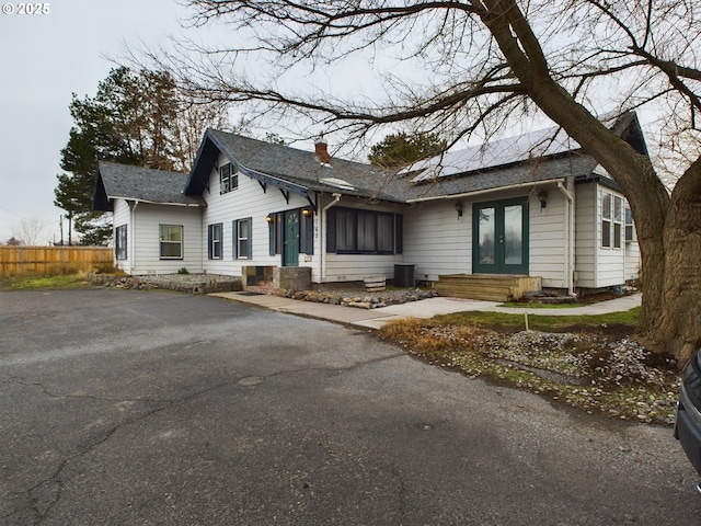 view of front of property featuring solar panels and french doors