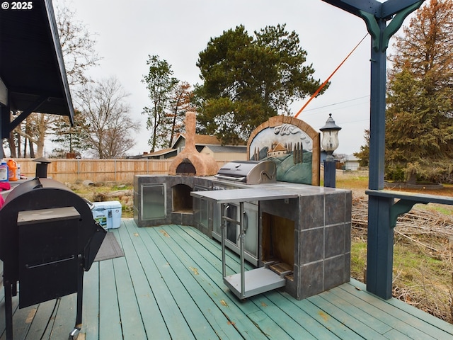 deck featuring area for grilling and exterior fireplace