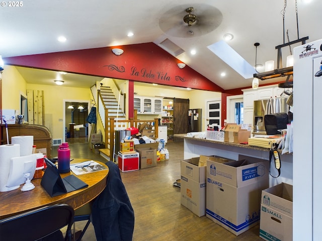 interior space with white cabinetry, ceiling fan, hanging light fixtures, stainless steel fridge, and vaulted ceiling