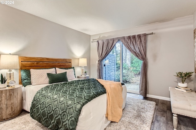 bedroom with access to exterior and dark wood-type flooring