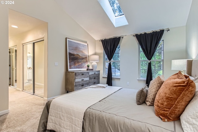 carpeted bedroom featuring lofted ceiling with skylight