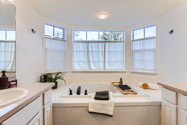 bathroom featuring vanity and tiled bath