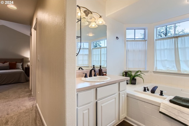 bathroom with vanity and a relaxing tiled tub