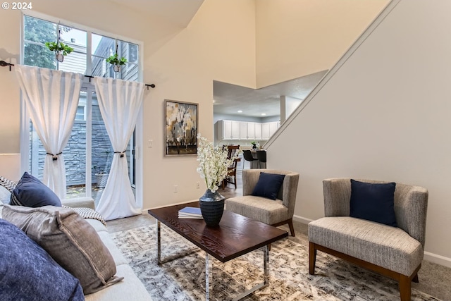 carpeted living room featuring a high ceiling